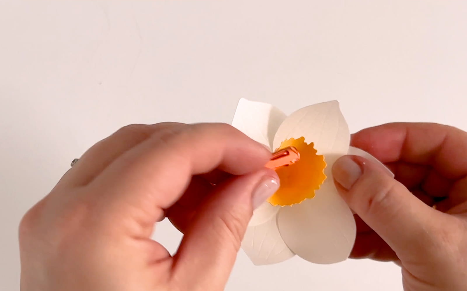 oranje papieren meeldraden toevoegen aan het midden van een narcis van knutselpapier