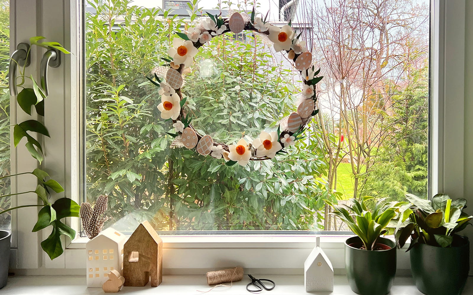 couronne de fleurs de Pâques en papercraft dans une fenêtre