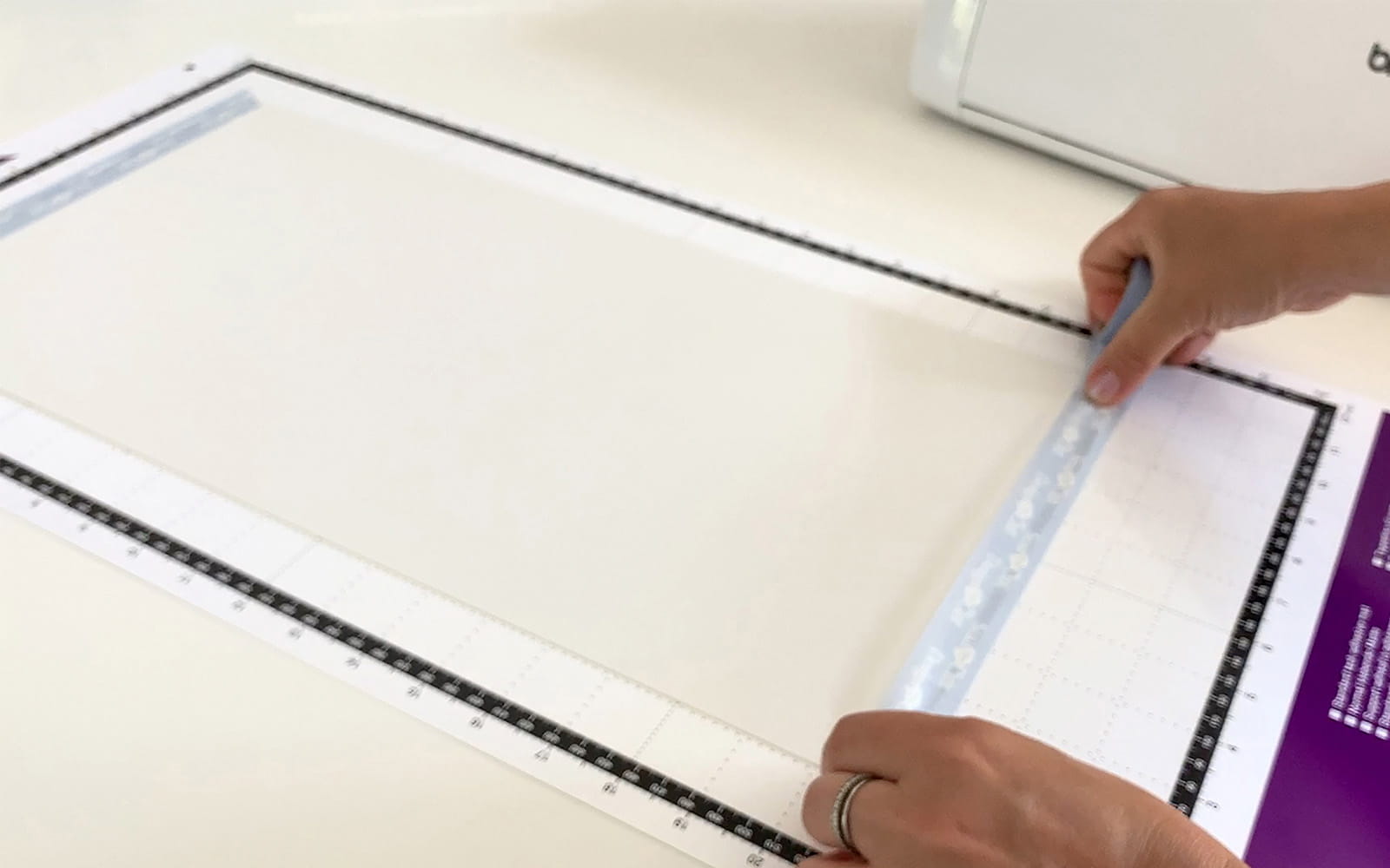 hands washi taping white polystyrene sheet to ScanNCut mat