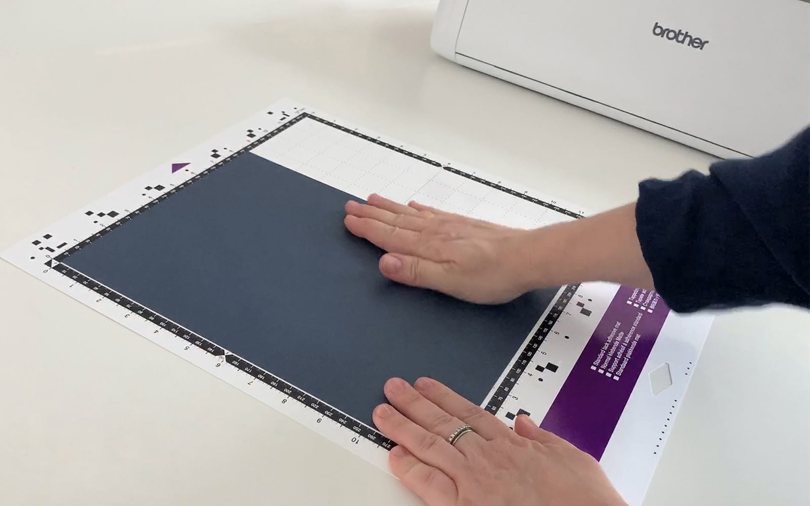 Hand adding square of black flex foil to ScanNCut cutting mat