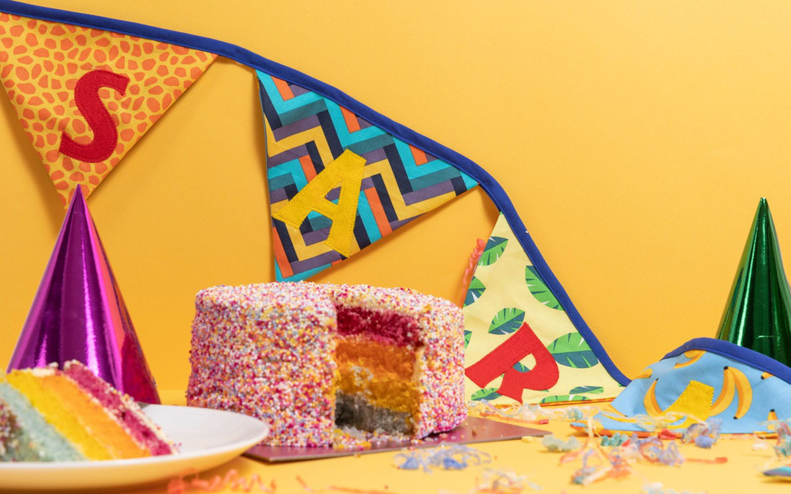 Birthday bunting on yellow background with cake and party hat