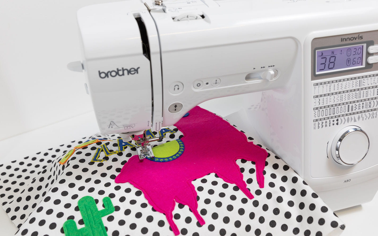 Spotty cushion cover with pink llama appliqué on Brother sewing machine