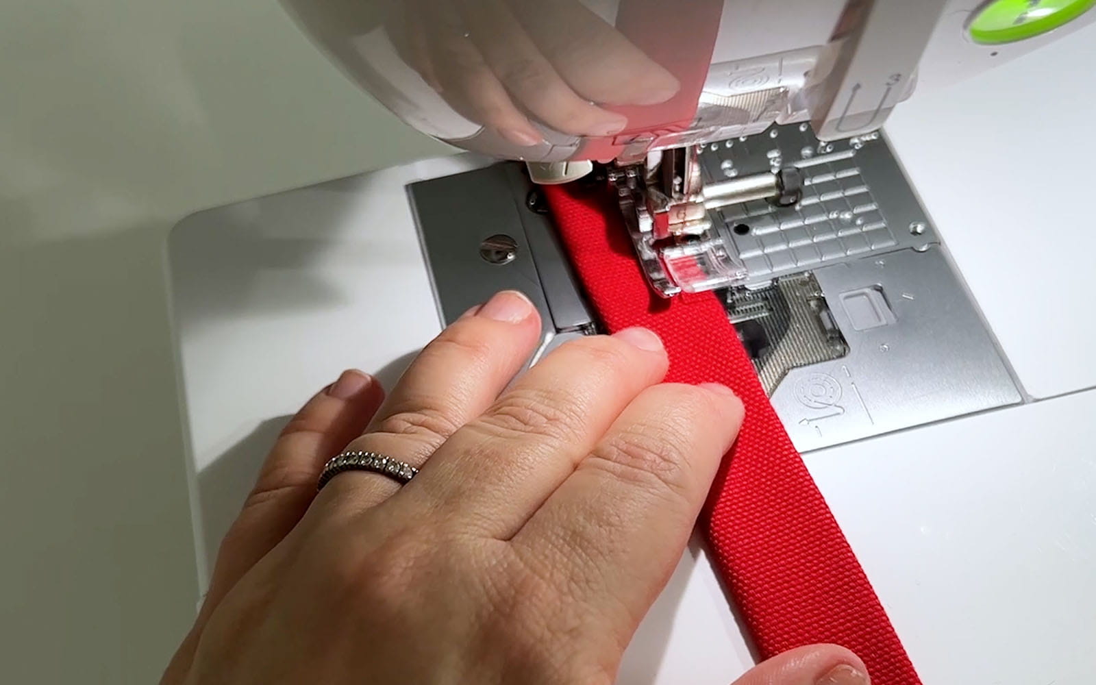 Red fabric strap in sewing machine