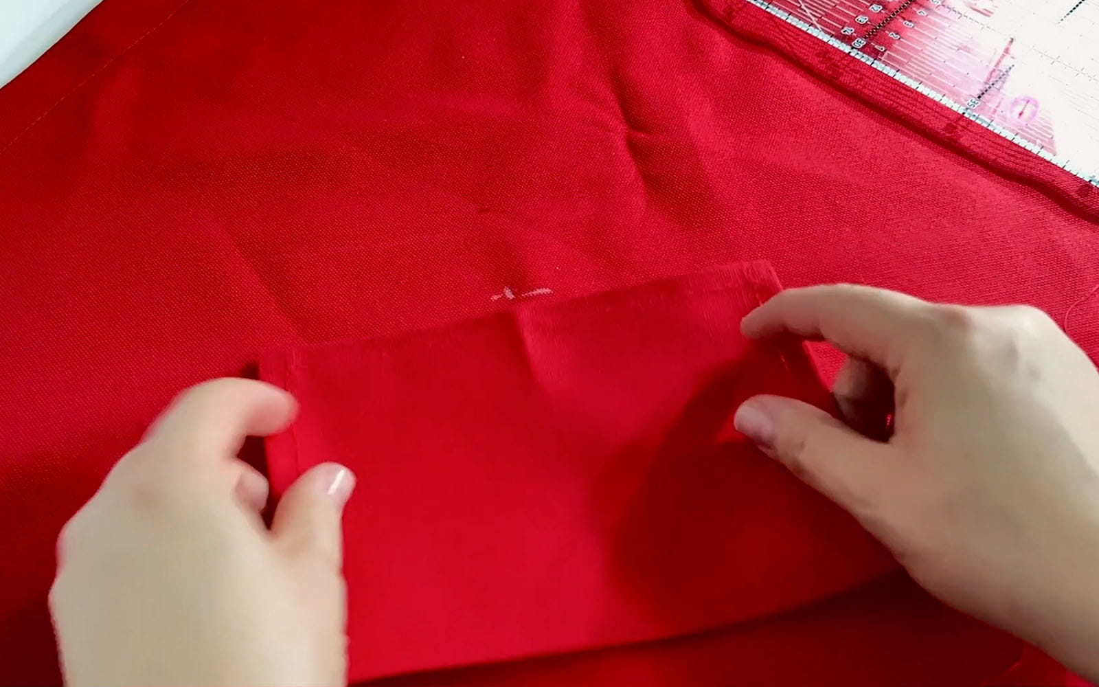 Placing red fabric pocket on apron
