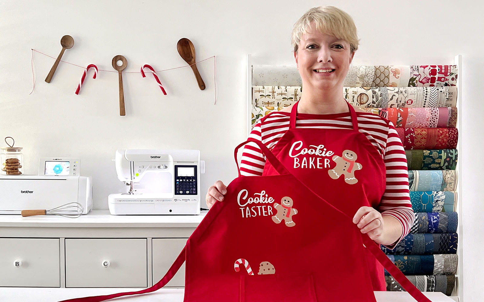 Ioana standing in her studio with 2 red aprons
