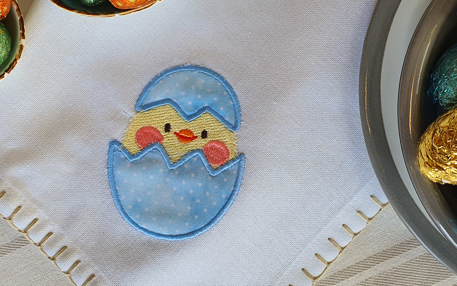 Blue and yellow chick embroidered on cream napkin