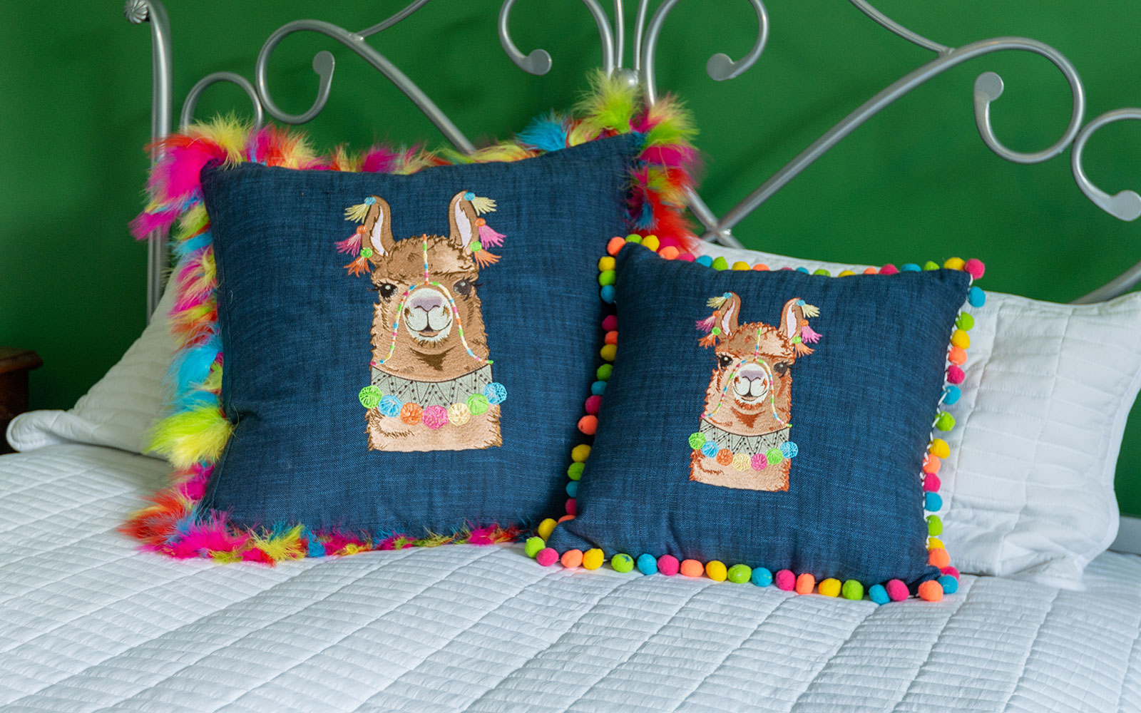 blue cushions with embroidered llama faces and multi-coloured tassels