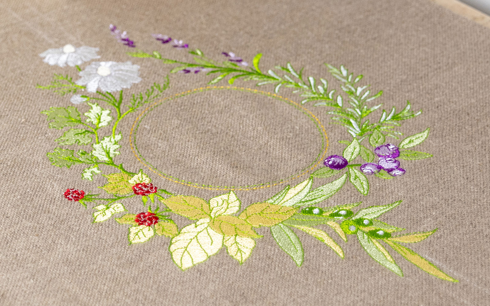 green, purple and gold embroidered wreath on light brown linen
