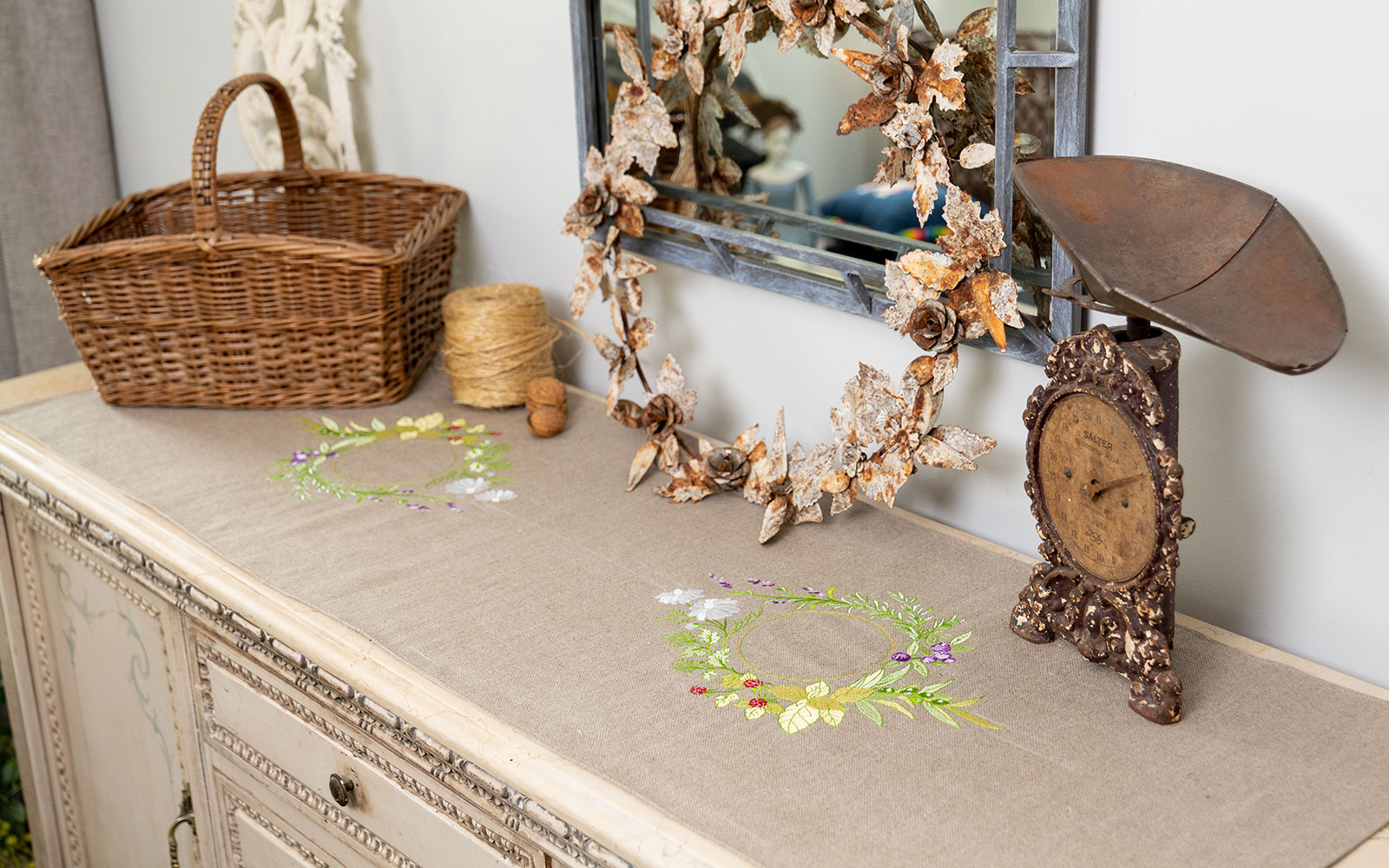 brown floral embroidered table runner on top of wooden sideboard