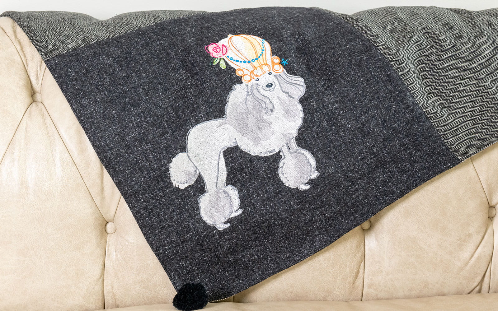 embroidered white cartoon poodle on beige sofa