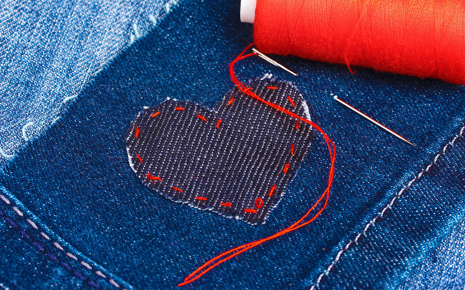 Heart shaped denim patch with red stitching round edge