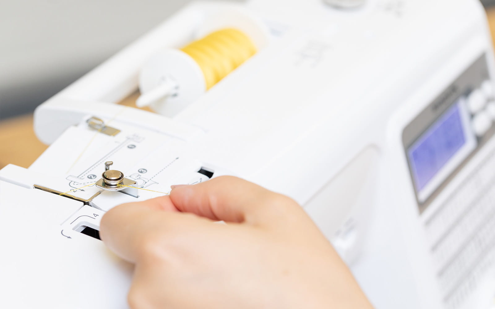 hand threading Brother sewing machine with yellow thread