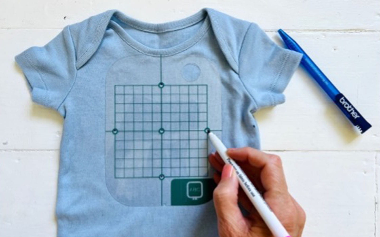 Blue babygrow with Brother embroidery grid sheet