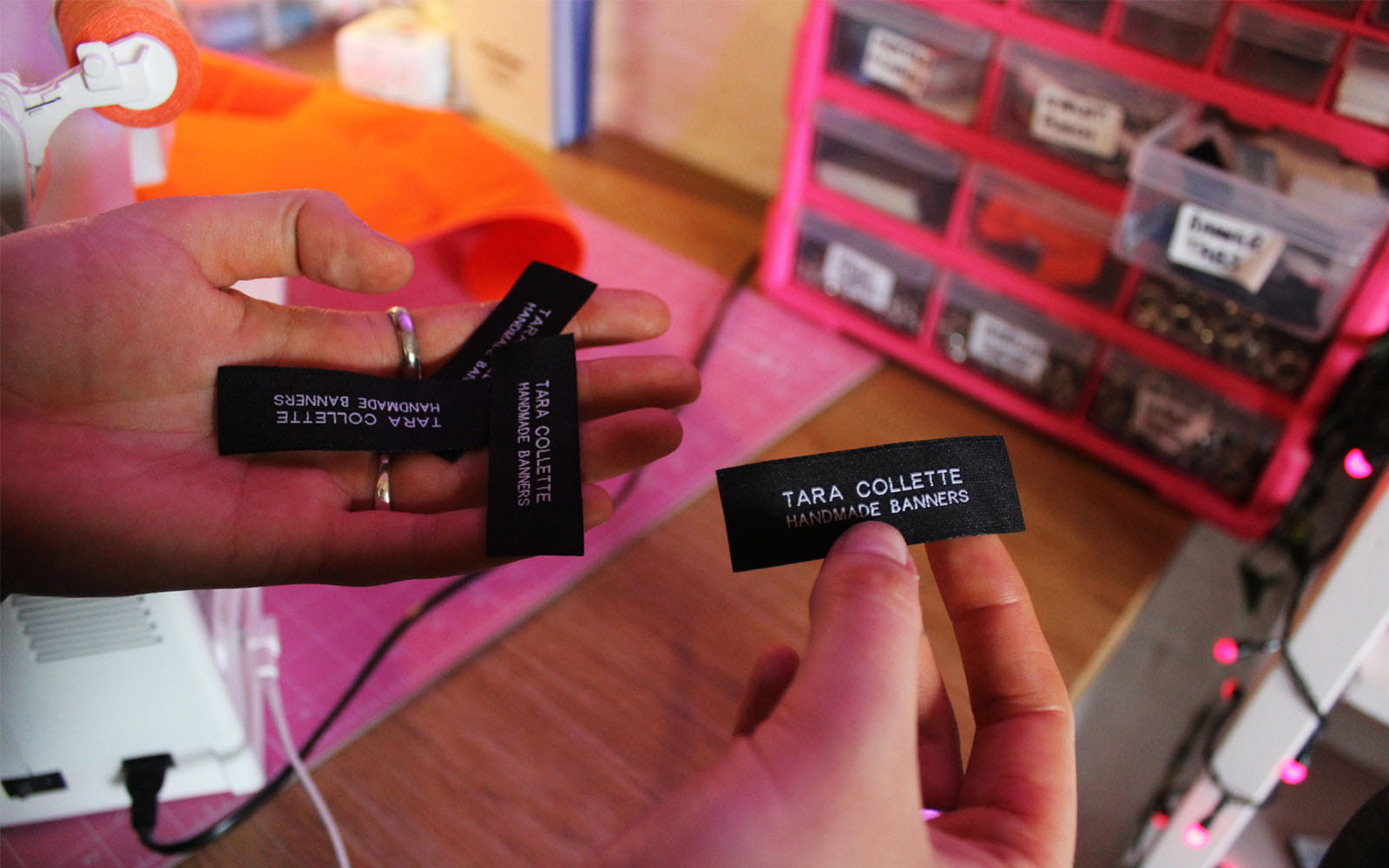 Hands holding black woven material tags