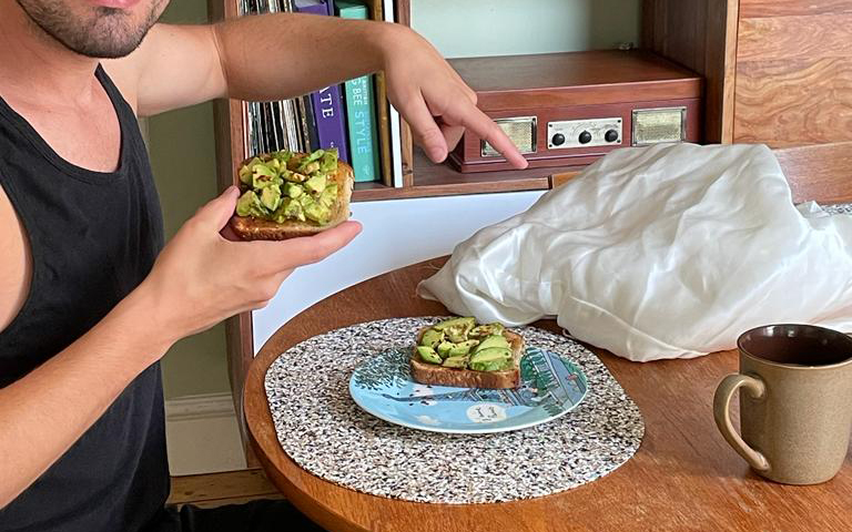 Raph Dilhan eating avo toast at a dining room table