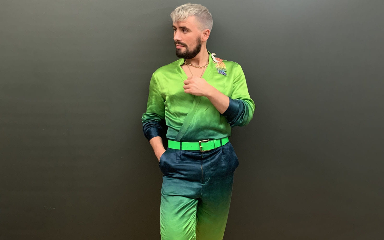 Raph Dilhan standing in ombre green and blue silk trouser suit