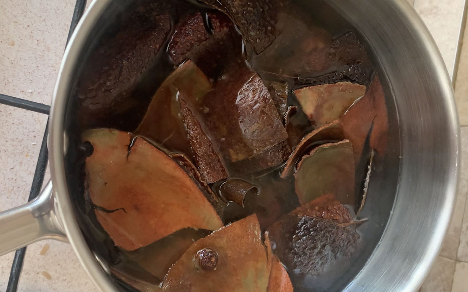 avocado skins in water in silver cooking pan