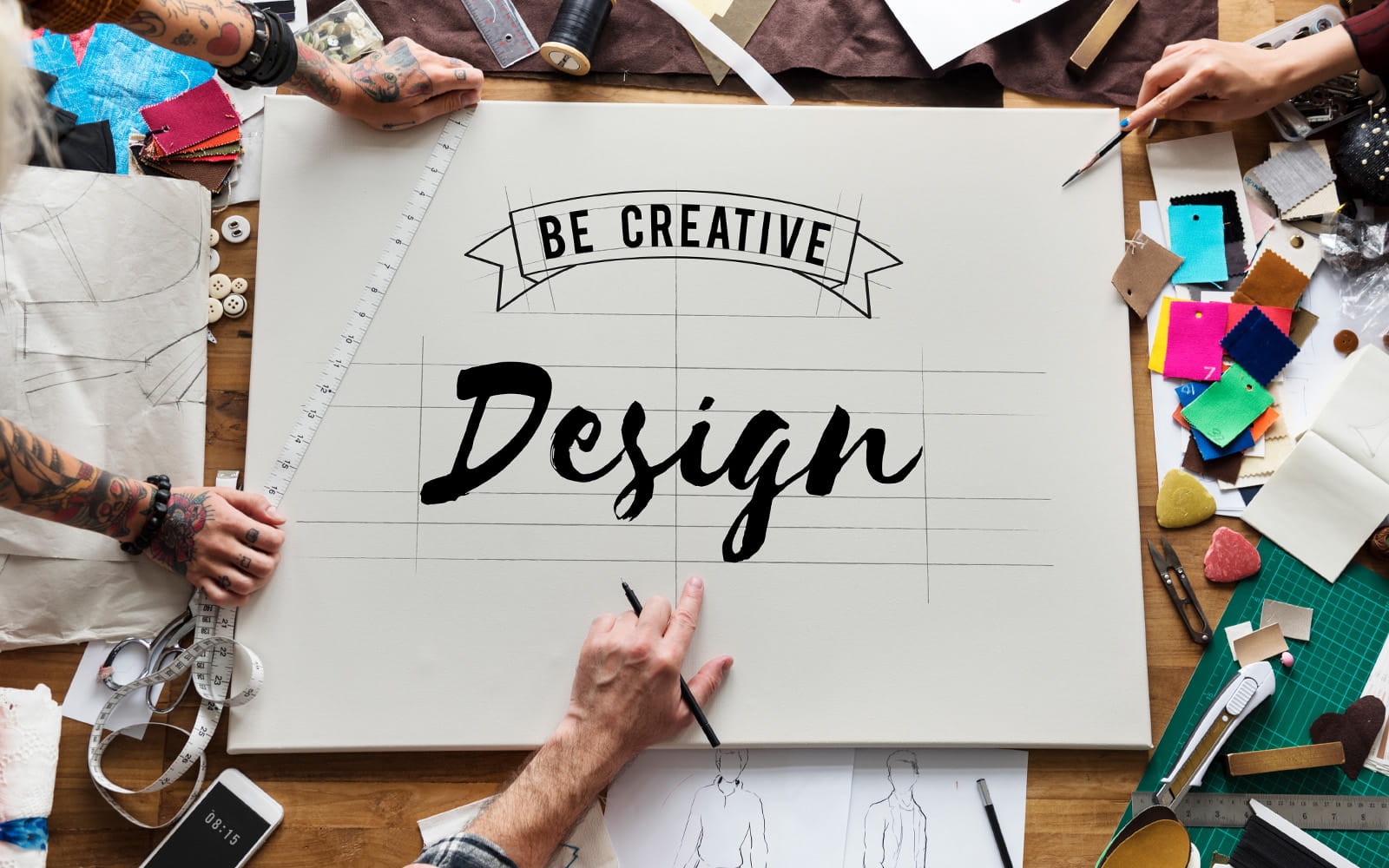 Handen en naaiaccessoires rond de woorden Be Creative Design