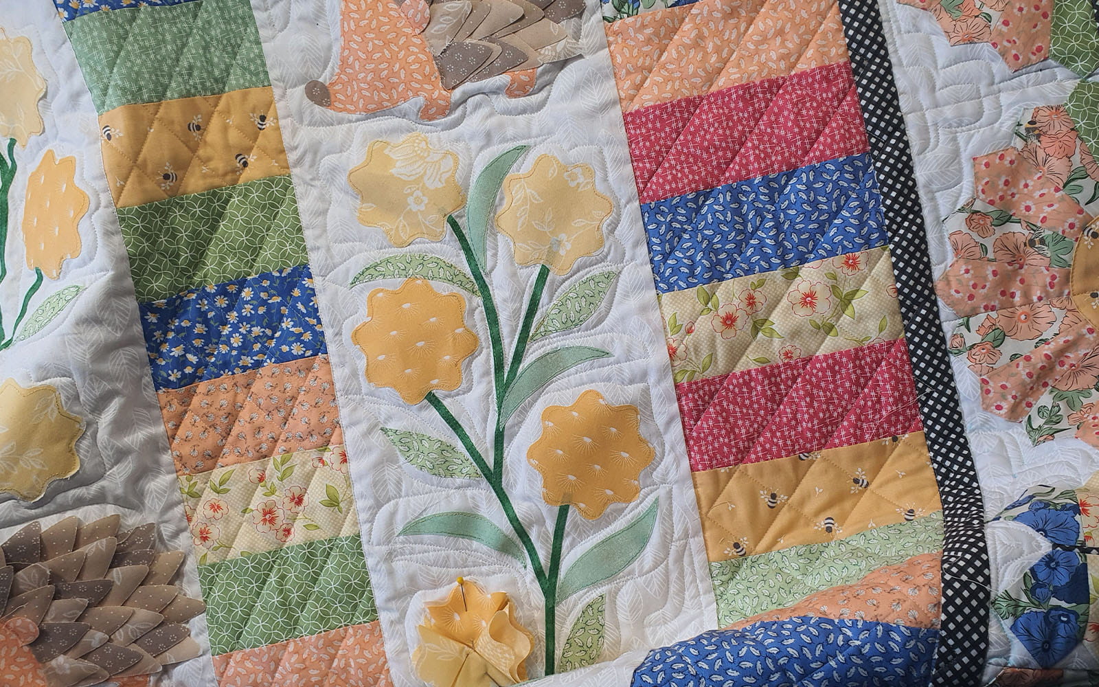 yellow fabric flower petal pinned on to quilt