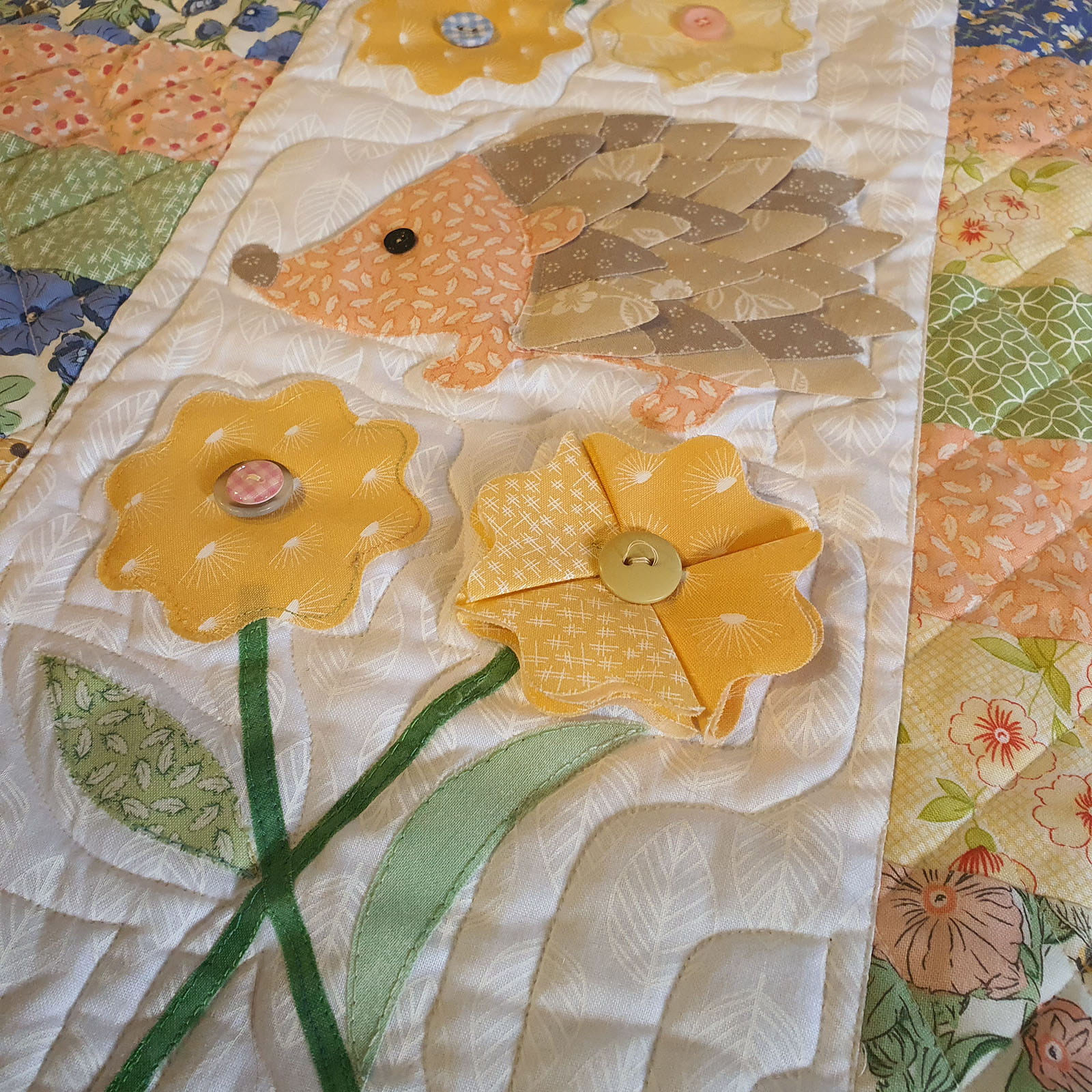 3D fabric flower and hedgehog on quilt background