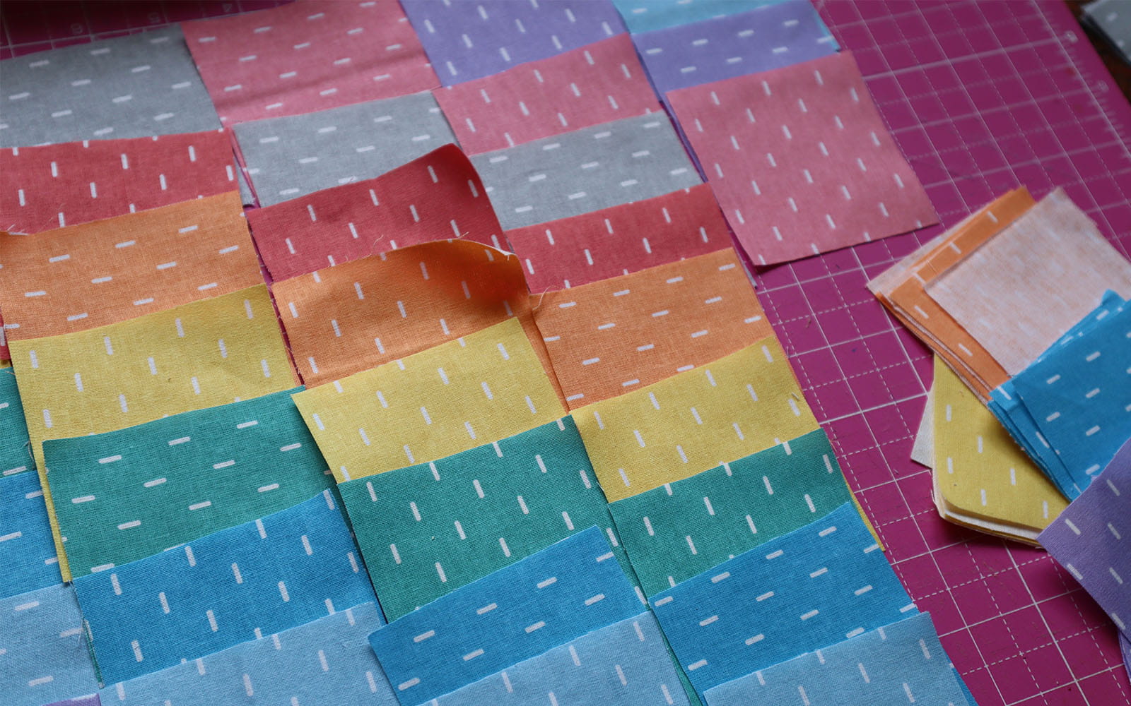 Different coloured fabric squares laid out in order