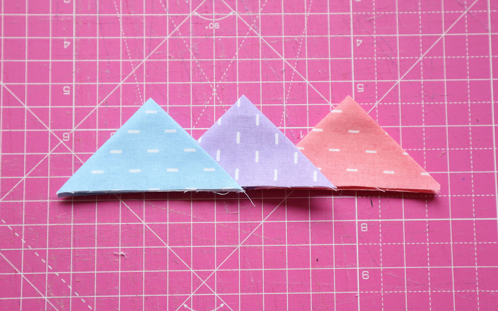 Blue, purple and orange double folded fabric triangles on pink mat