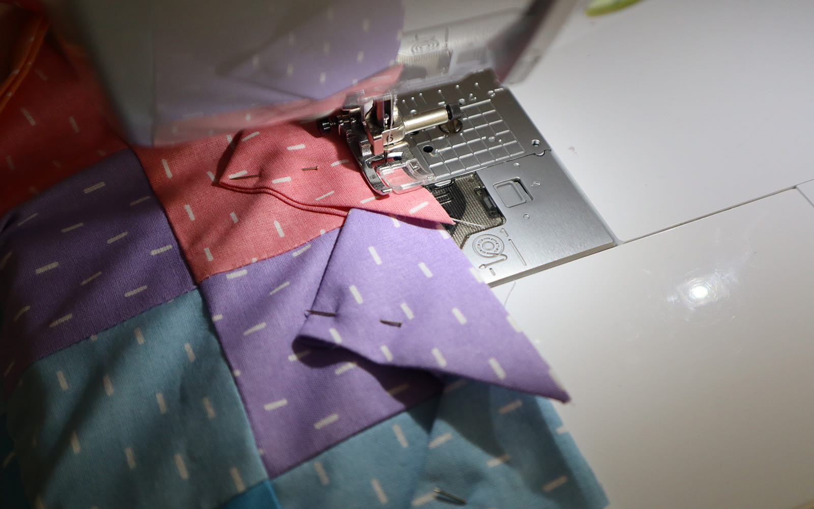 Triangles being stitched to the edge of the square fabric