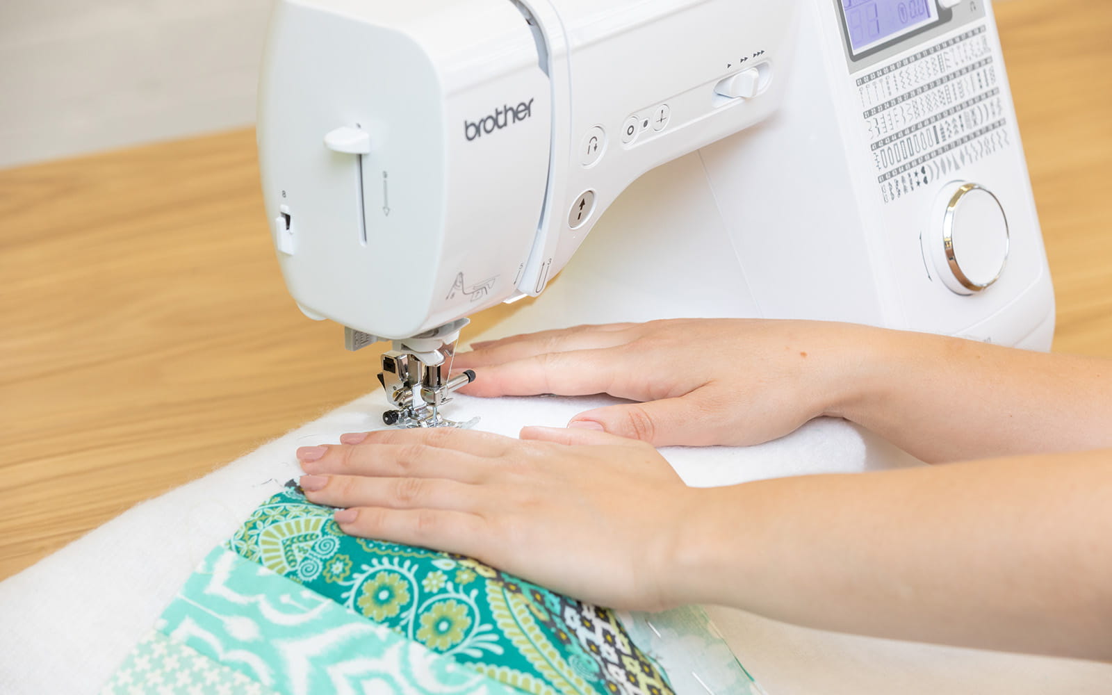 hands sewing green quilt as you go placemat on brother sewing machine