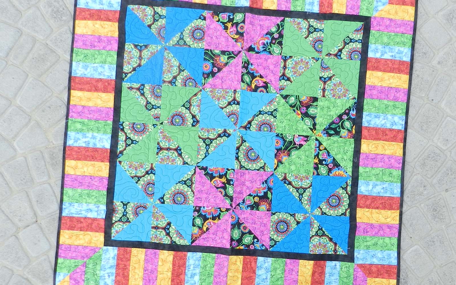 Colourful quilt on paving stones