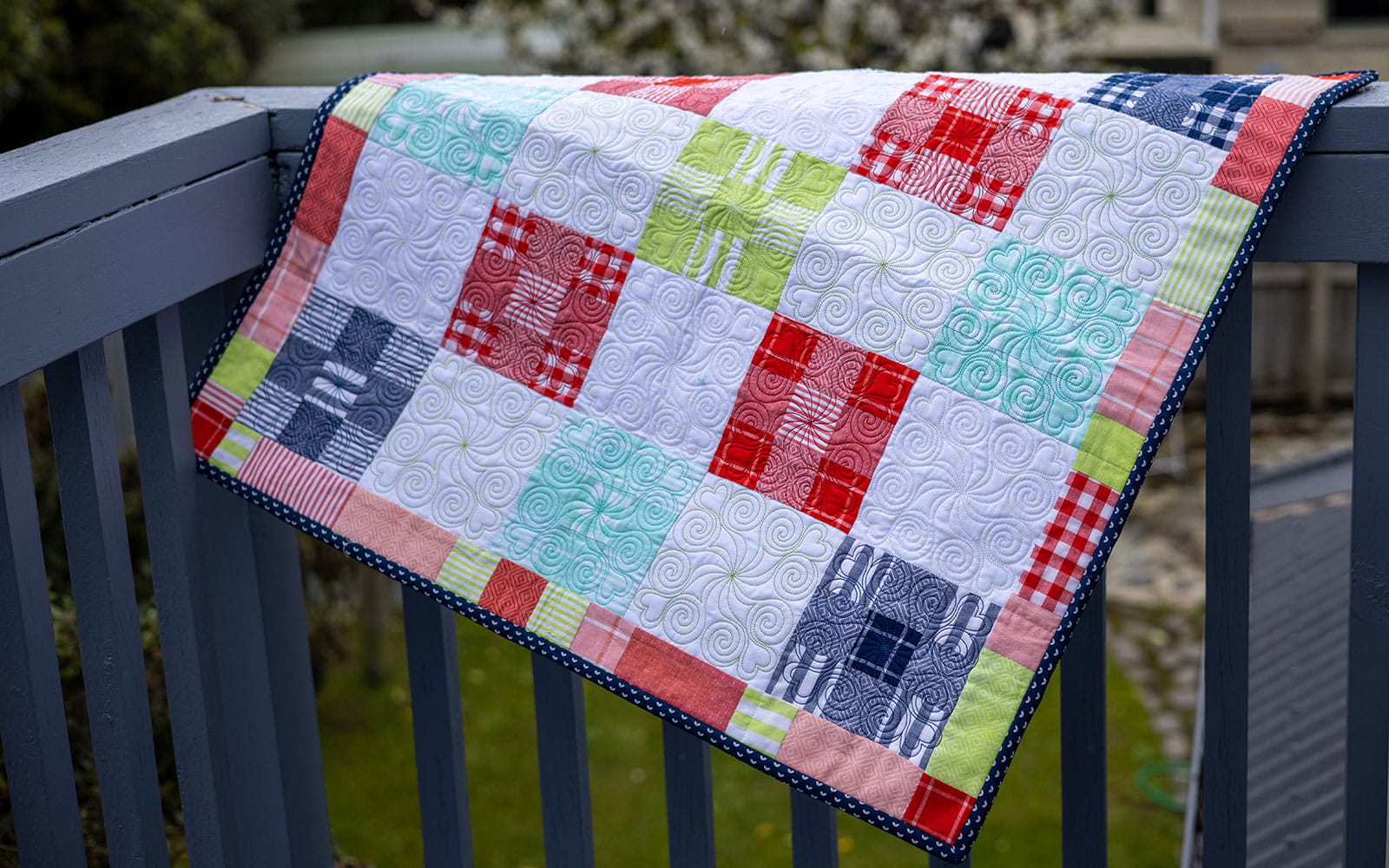 een quilt van rode, witte en groene vierkante blokken