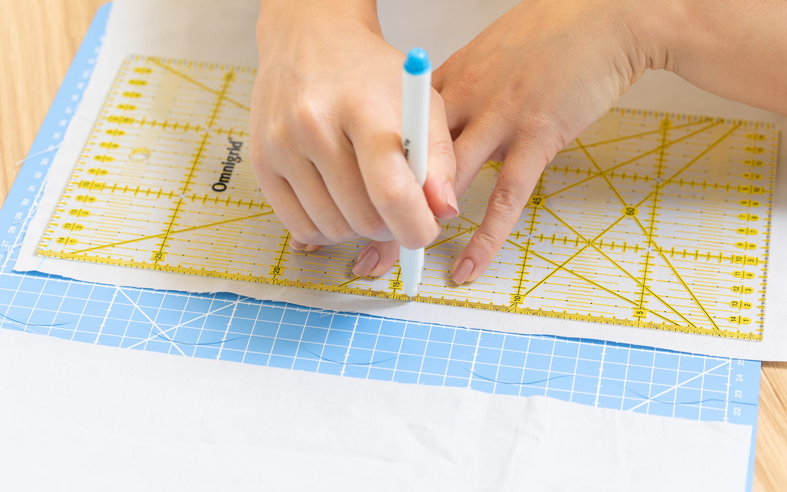 Hands using sewing ruler to mark out seam allowance