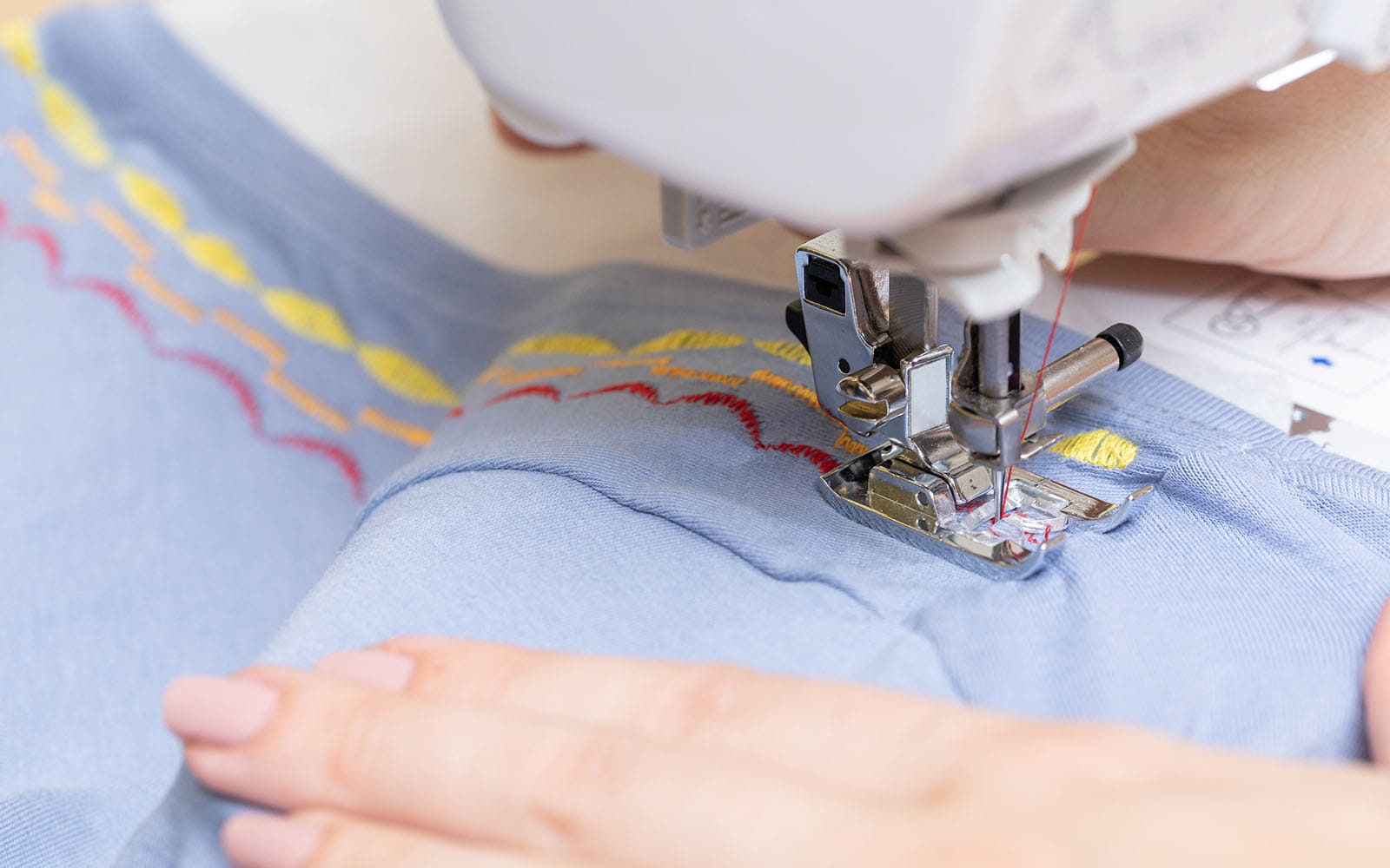 Sewing decorative stitches round blue T-shirt neckline