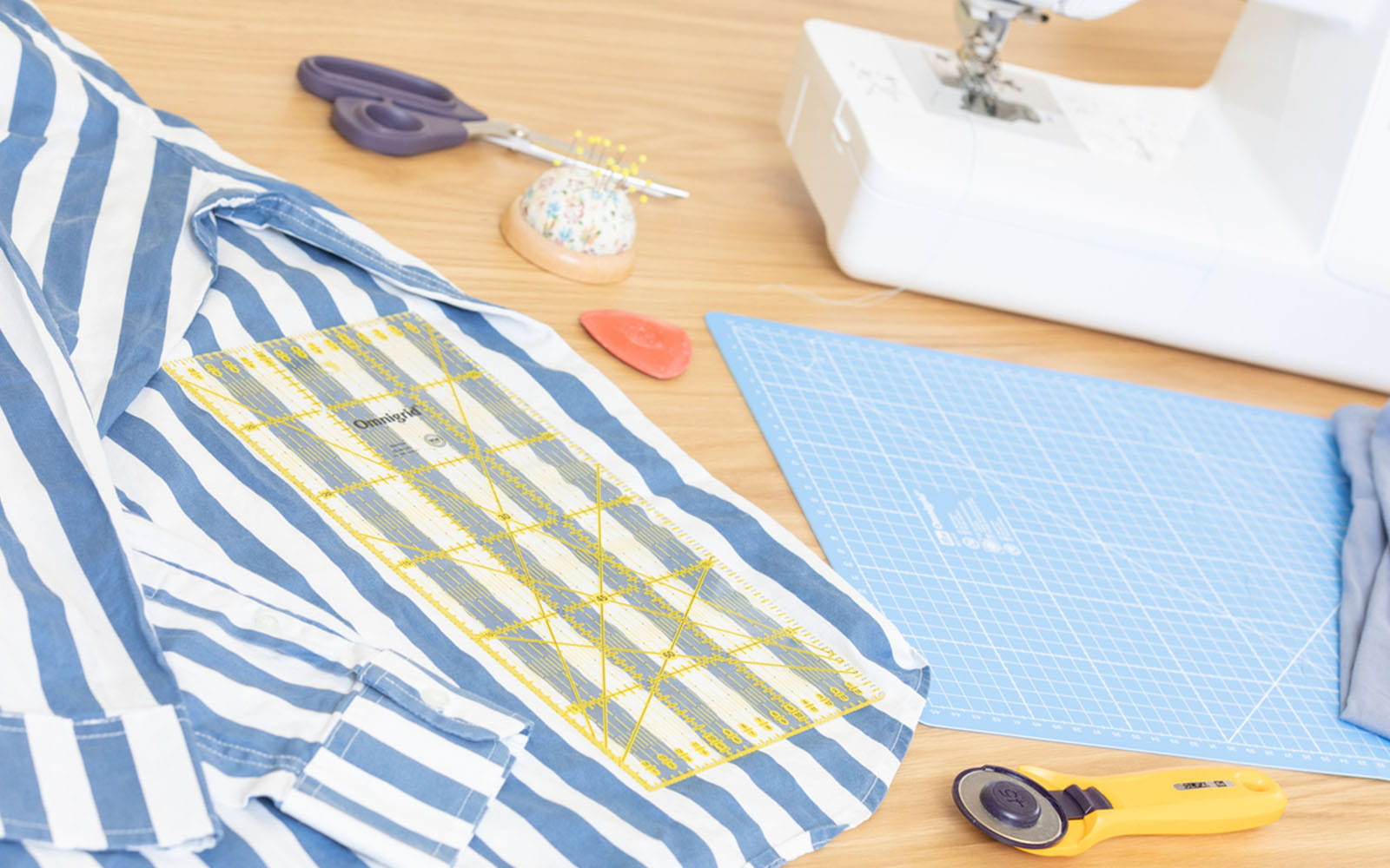 Chemise bleue et blanche et matériel de couture sur table