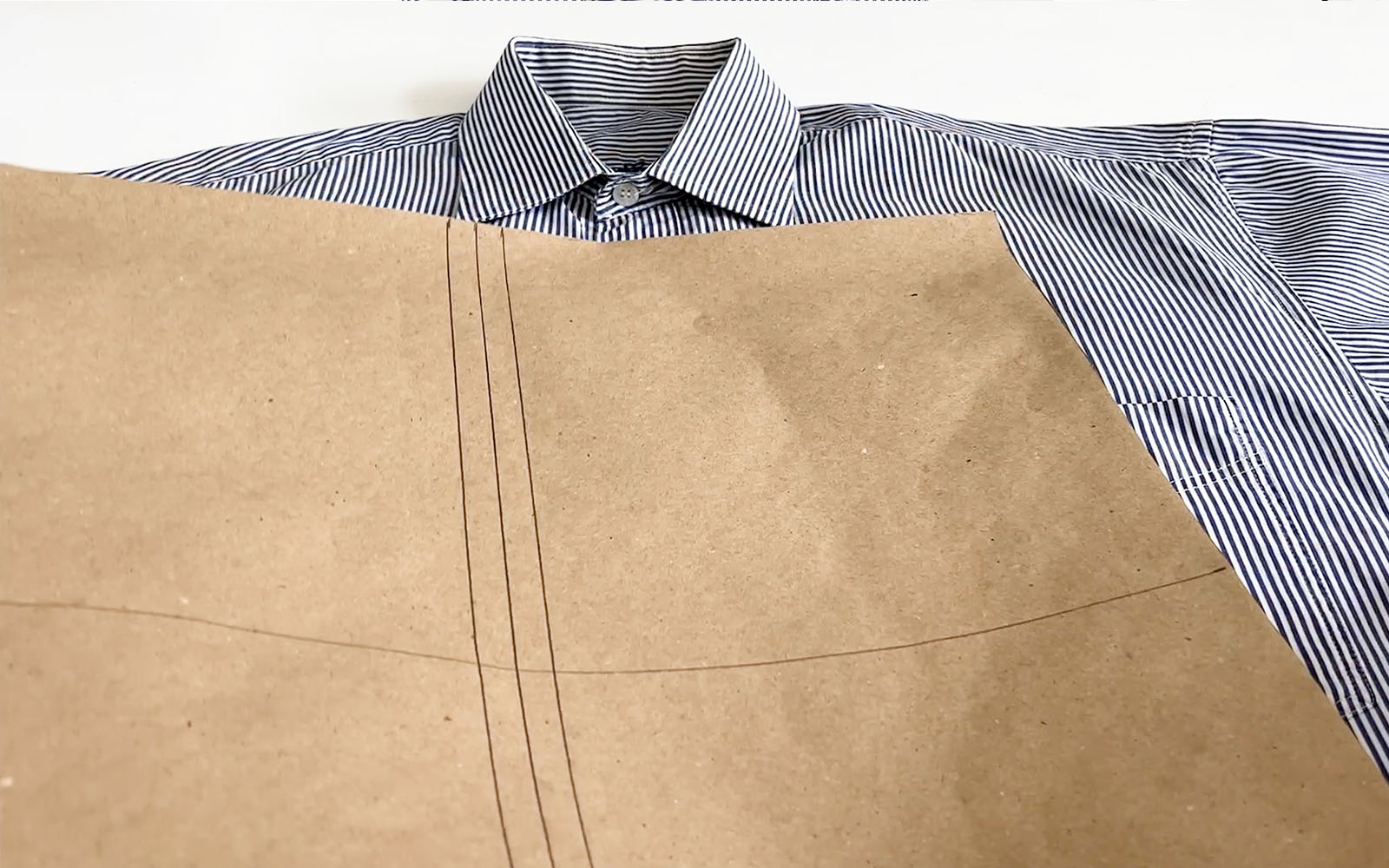 Gabarit en papier brun sur chemise à rayures