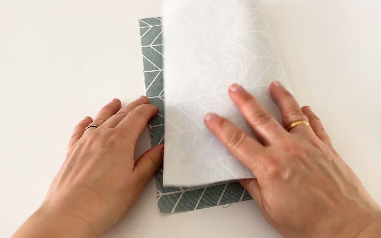Hands folding fabric and stabiliser in half