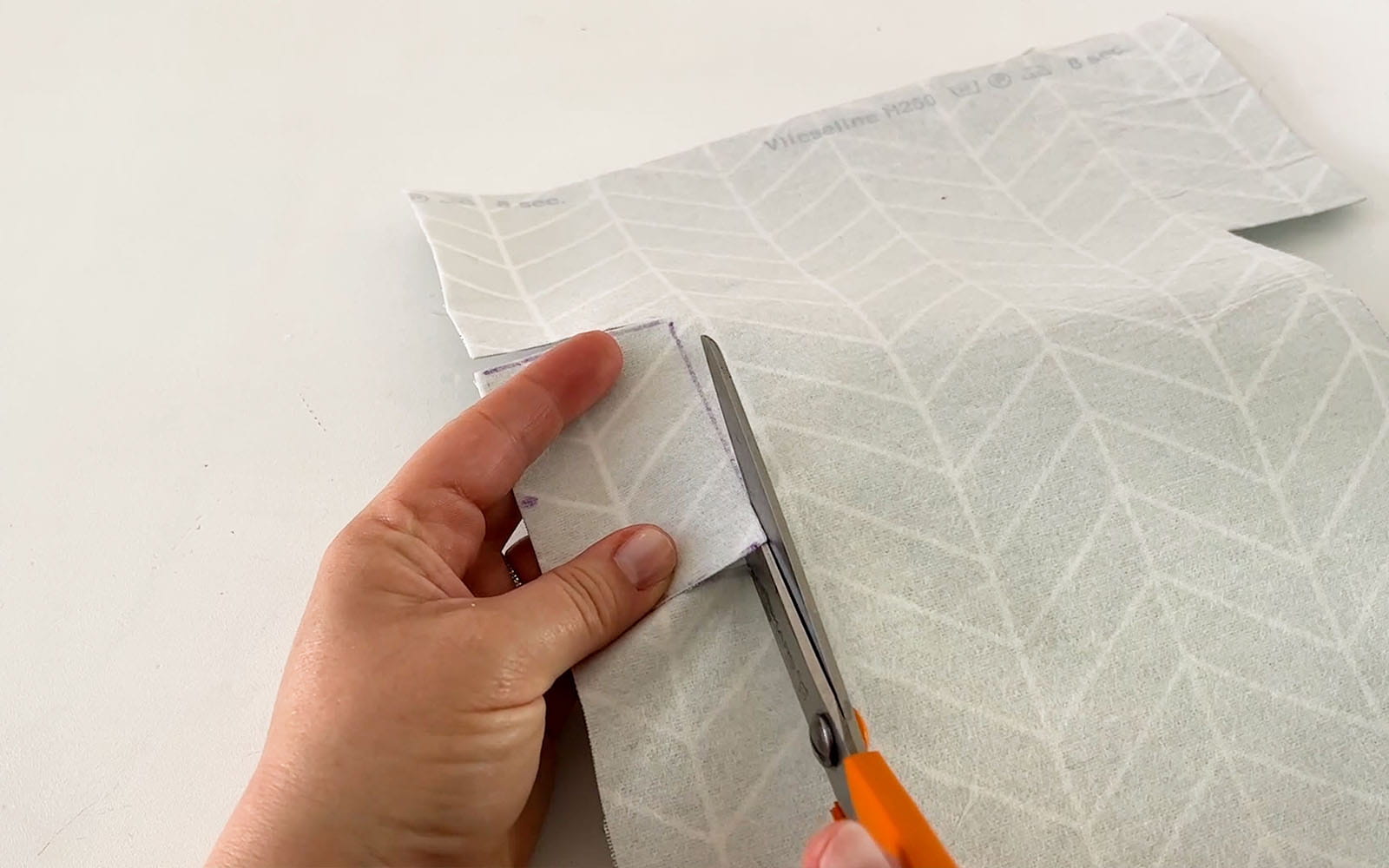 Scissors cutting rectangle out of fabric