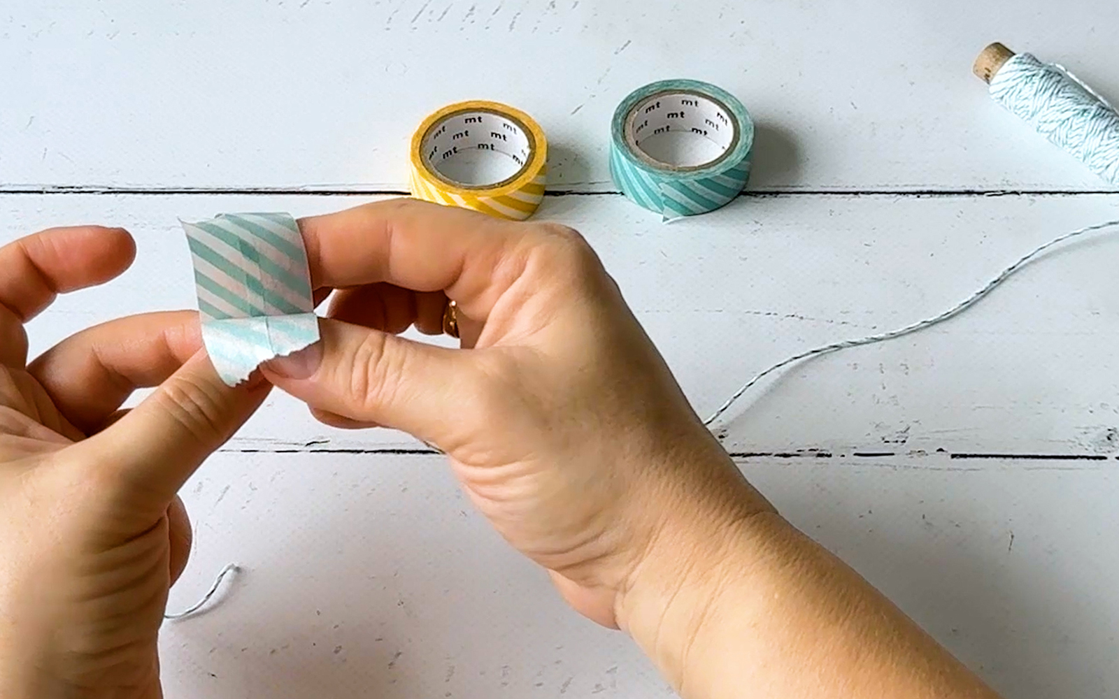 Hands sticking two pieces of tape together