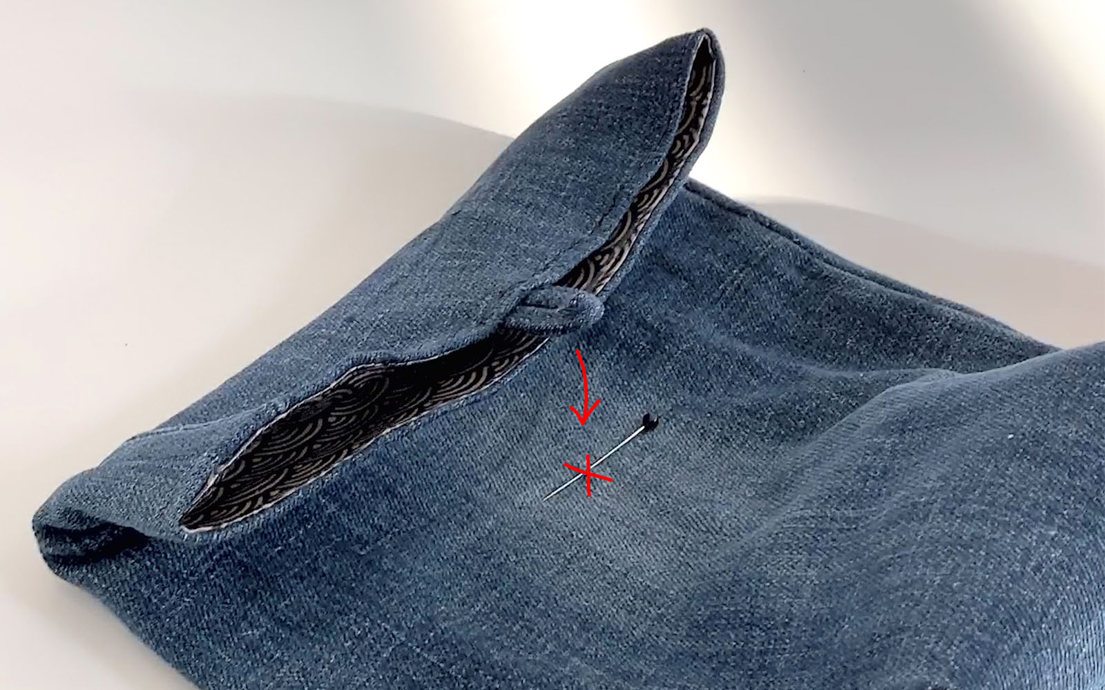 small denim bag with pin where button needs to be sewn to close