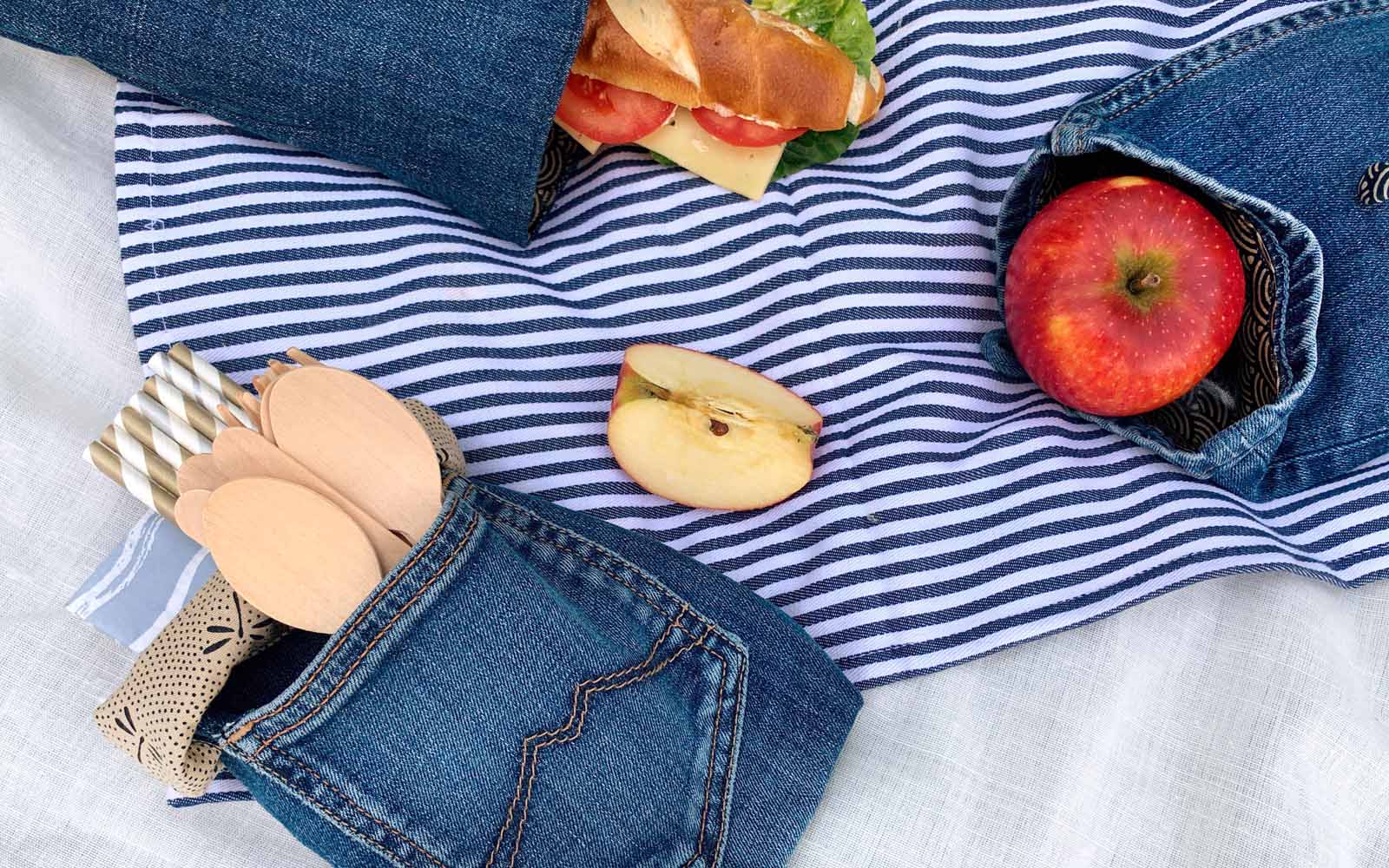 cutlery apple and baguette in denim bags flat lay