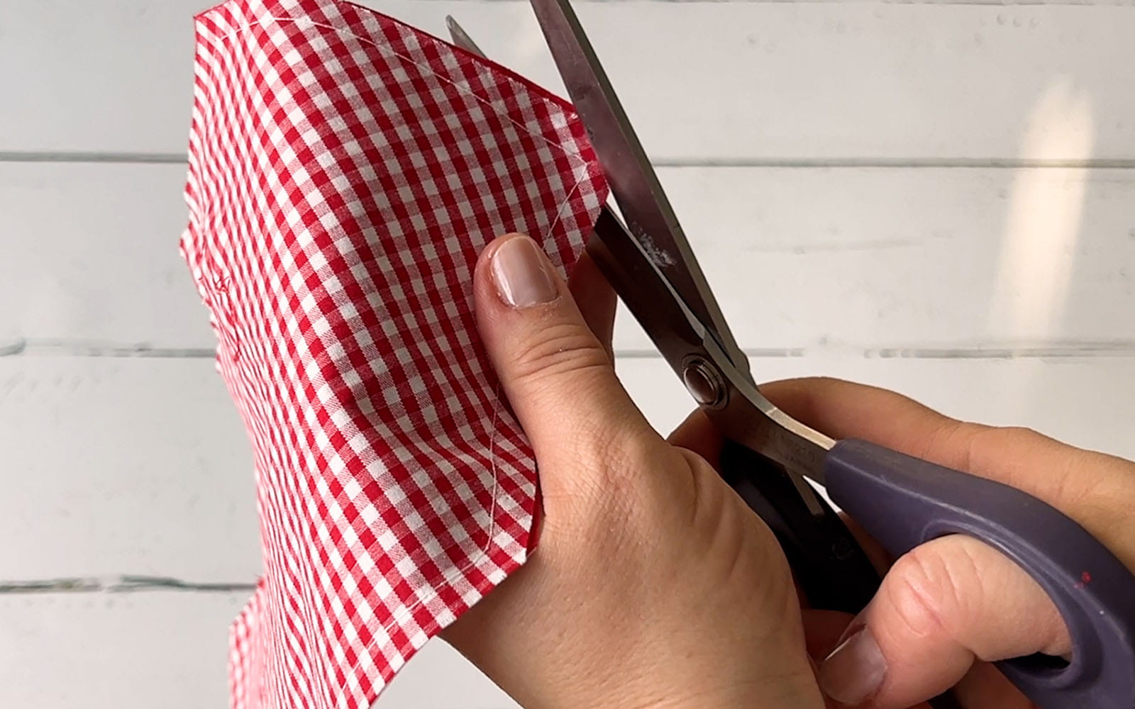 Corners bring trimmed by scissors on sewn gingham fabric envelope