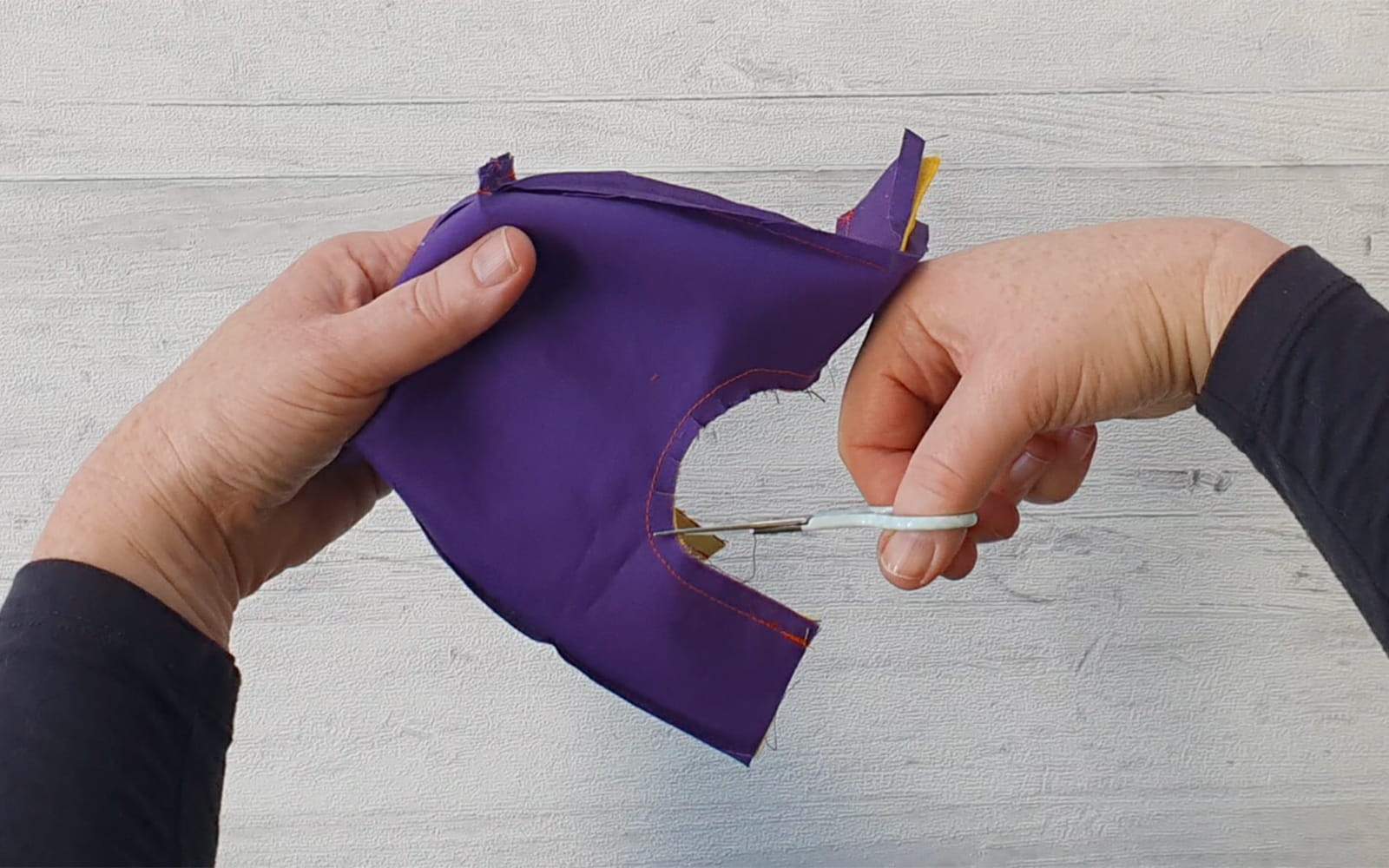 Cutting knotches into purple mini bag