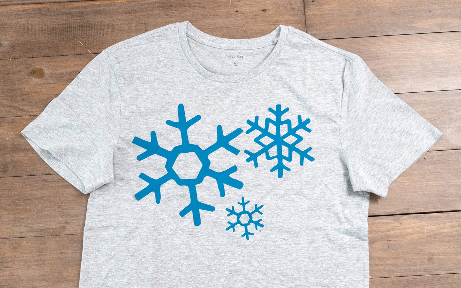 Blue vinyl snowflakes on grey t-shirt