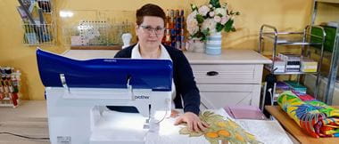 Dr Lili Mihai sitting at her Brother XVD 8000 quilting machine