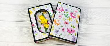 Floral card with box on wooden background