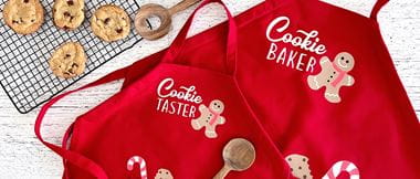 2 red aprons on white background with cookies on the side
