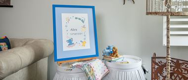 embroidered sampler with baby name and birth date in blue frame 