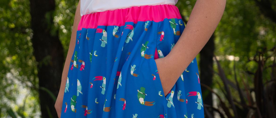 Ladies hand in pocket of blue skirt with bright pink accents