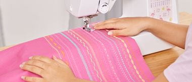 Sewing stitch examples on pink fabric in Brother sewing machine