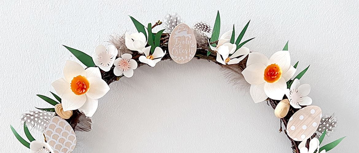 paper craft flowers and balsa wood eggs on wooden wreath