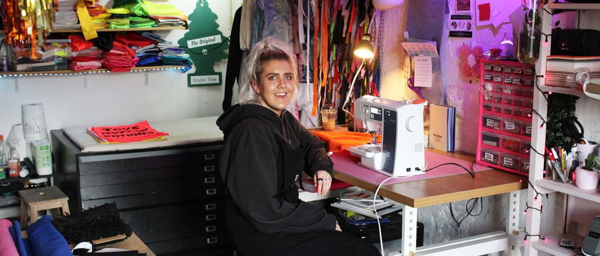 Vrouw zit aan een bureau met Brother naaimachine